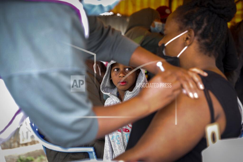 Brian Inganga A Kenyan woman receives a dose of AstraZeneca coronavirus vaccine donated by Britain, as her son watches, at the Makongeni Estate in Nairobi, Kenya Saturday, Aug. 14, 2021. In late June, the international system for sharing coronavirus vaccines sent about 530,000 doses to Britain – more than double the amount sent that month to the entire continent of Africa. It was the latest example of how a system that was supposed to guarantee low and middle-income countries vaccines is failing, leaving them at the mercy of haphazard donations from rich countries. (AP Photo/Brian Inganga)