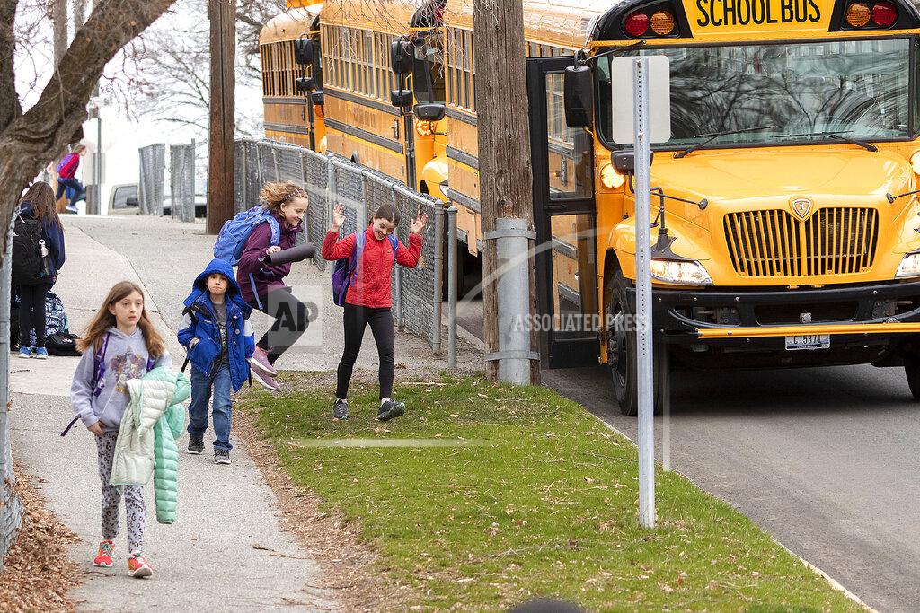 FILE - In this March 13, 2020 file photo, children head home after the last day of school before spring break, and eventual closure due to the coronaviurs utbreak, outside Russell Elementary School in Moscow, Idaho. With schools closed and teachers unable to report suspected cases of abuse and neglect, child welfare agencies have lost some of their best eyes and ears during a highly stressful time for families who have lost jobs and are locked down together at home. April is Child Abuse Prevention Month, but across the country, states are reporting fewer calls to child abuse hotlines, worrying child welfare officials that abuse is going unreported during the coronavirus pandemic.(Geoff Crimmins/The Moscow-Pullman Daily News via AP, File)