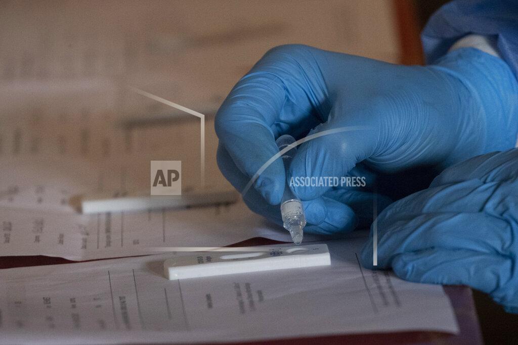 Alessandra Tarantino A medical staffer examines samples to test for coronavirus in the help center of the charity group Binario 95 (Track 95), at Rome's Termini station, Thursday, Nov. 12, 2020. Hundreds of homeless people and those who help care for them are receiving free COVID-19 swab tests. The initiative is carried out with the involvement of San Gallicano Institute, a hospital in the Italian capital, as well as with assistance of a charity group called Binario 95. (AP Photo/Alessandra Tarantino)