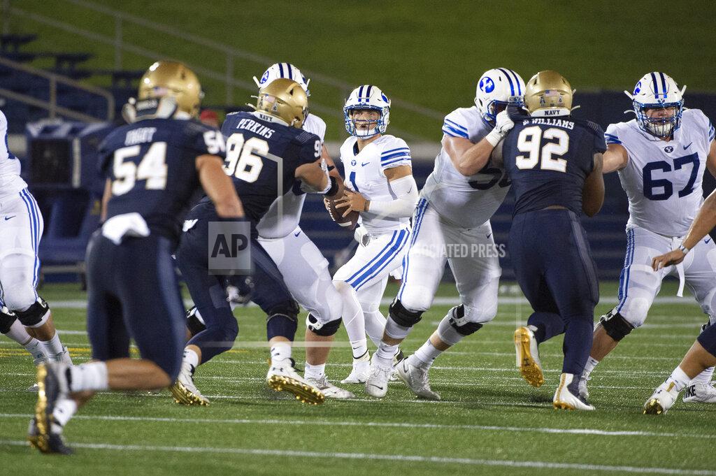 Tommy Gilligan BYU quarterback Zach Wilson, center, looks to throw downfield as Navy defensive tackles Jackson Perkins (96) and Deondrae Williams (92) apply pressure during the first half of an NCAA college football game, Monday, Sept. 7, 2020, in Annapolis, Md. (AP Photo/Tommy Gilligan)