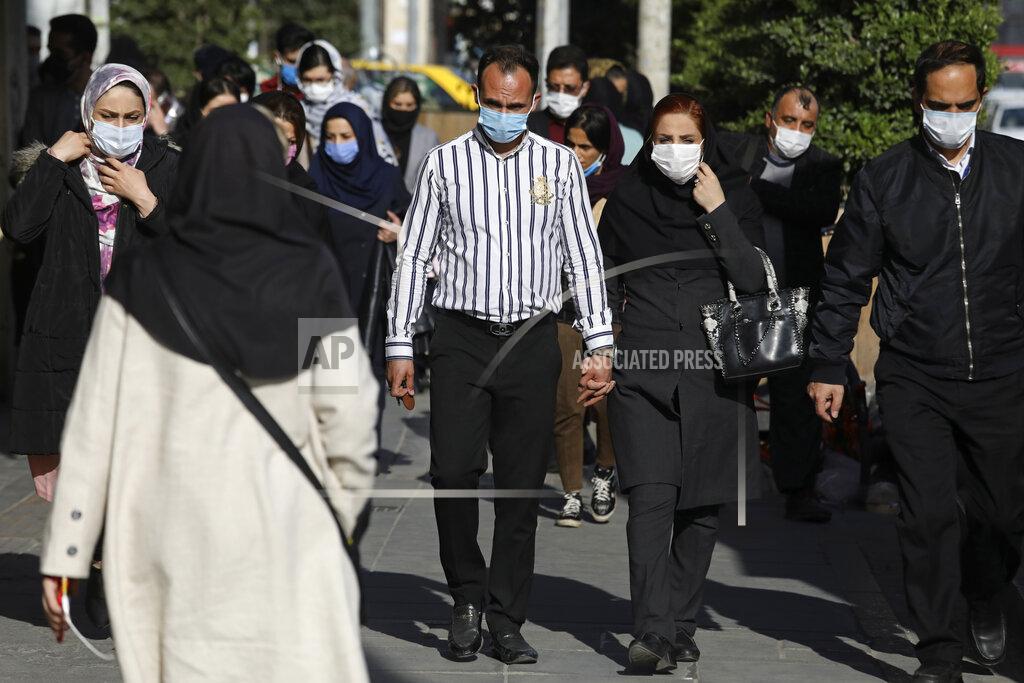 Vahid Salemi FILE - In this April 5, 2021, file photo, people wearing protective face masks to help prevent the spread of the coronavirus walk in downtown Tehran, Iran. Nations around the world set new records Thursday, April 8, for COVID-19 deaths and new coronavirus infections, and the disease surged even in some countries that have kept the virus in check. Iran set a new coronavirus infection record Thursday for the third straight day, reporting nearly 22,600 new cases. (AP Photo/Vahid Salemi, File)