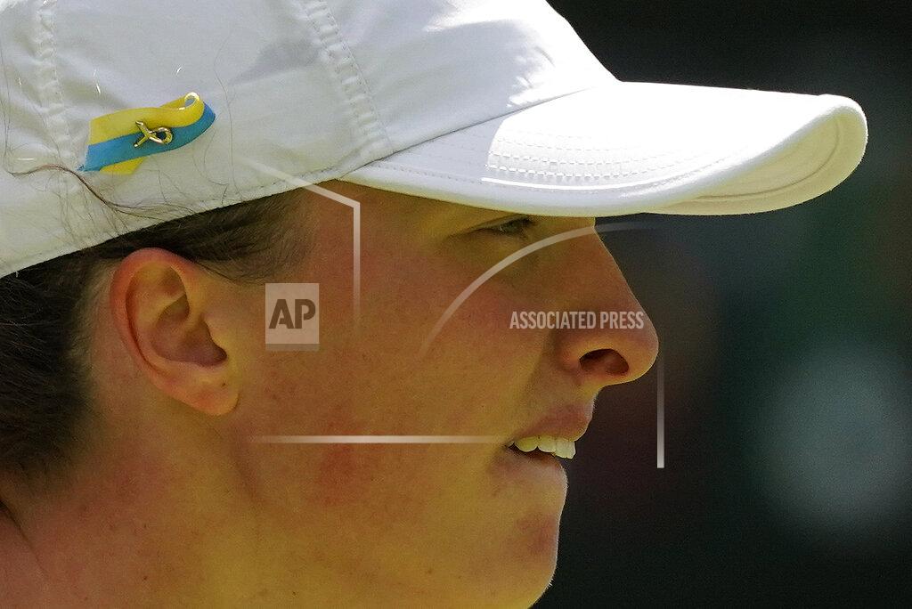 Alberto Pezzali Poland's Iga Swiatek sporting a Ukrainian colors ribbon on her hat waits to receive serve from Croatia's Jana Fett in a first round women's singles match on day two of the Wimbledon tennis championships in London, Tuesday, June 28, 2022. (AP Photo/Alberto Pezzali)
