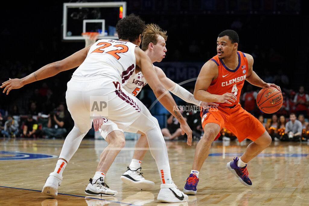John Minchillo Clemson Tigers' Nick Honor (4) looks to pass against Virginia Tech's Storm Murphy (5) and Keve Aluma (22) in the first half of an NCAA college basketball game during the Atlantic Coast Conference men's tournament, Wednesday, March 9, 2022, in New York. (AP Photo/John Minchillo)