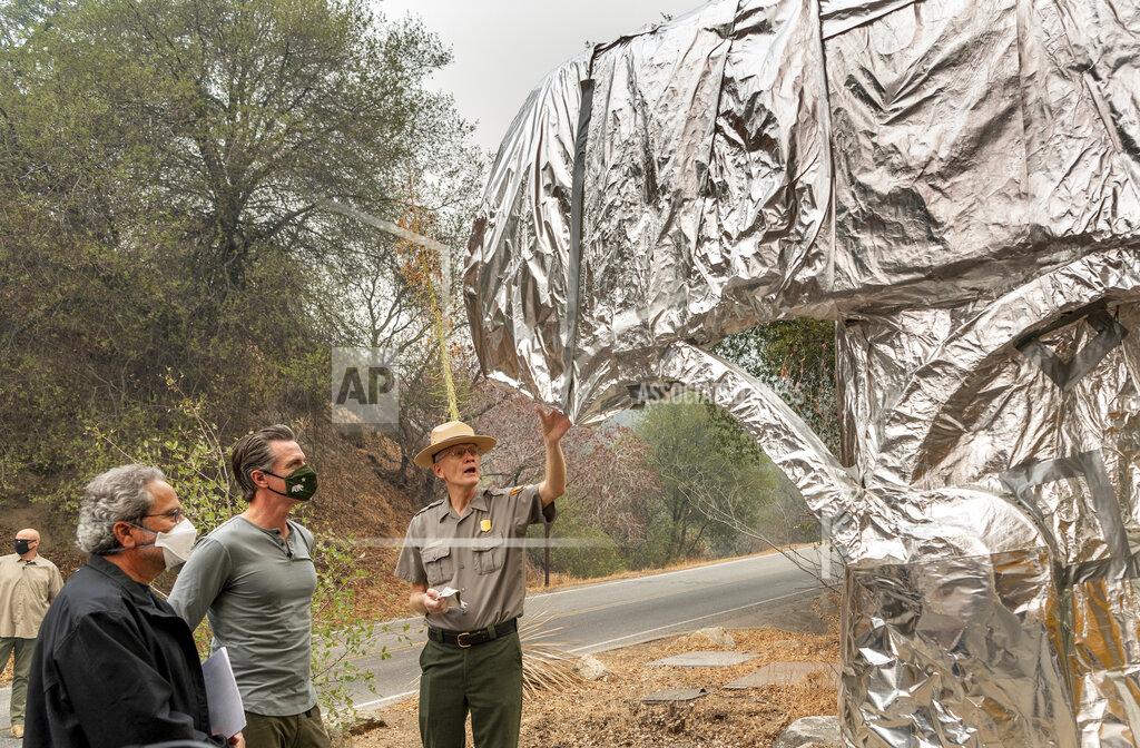 Ron Holman State Assembly Member Richard Bloom, D-Santa Monica, left, and California Gov. Gavin Newsom, second left, listen to Superintendent of Sequoia and Kings Canyon National Parks Clay Jordan, right, talk about the protective structure wrap used to protect the welcome sign and giant sequoia trees from the KNP Complex Fire, on Thursday, Sept. 23, 2021, in Sequoia National Park, Calif. Newsom on Thursday approved nearly $1 billion in new spending to prevent wildfires, signaling a policy shift in a state that historically focused more on putting out fires than stopping them before they start. (Ron Holman/The Times-Delta via AP)