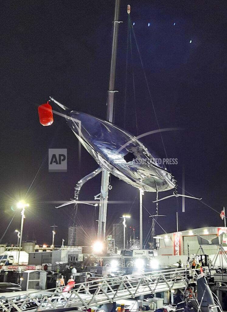 Will Trafford United States' American Magic's damaged boat, Patriot is lifted out of the water at its team base after it capsized during its race against Italy's Luna Rossa on the third day of racing of the America's Cup challenger series on Auckland's Waitemate Harbour, New Zealand, Sunday, Jan. 17, 2021. (Will Trafford/NZ Herald via AP)