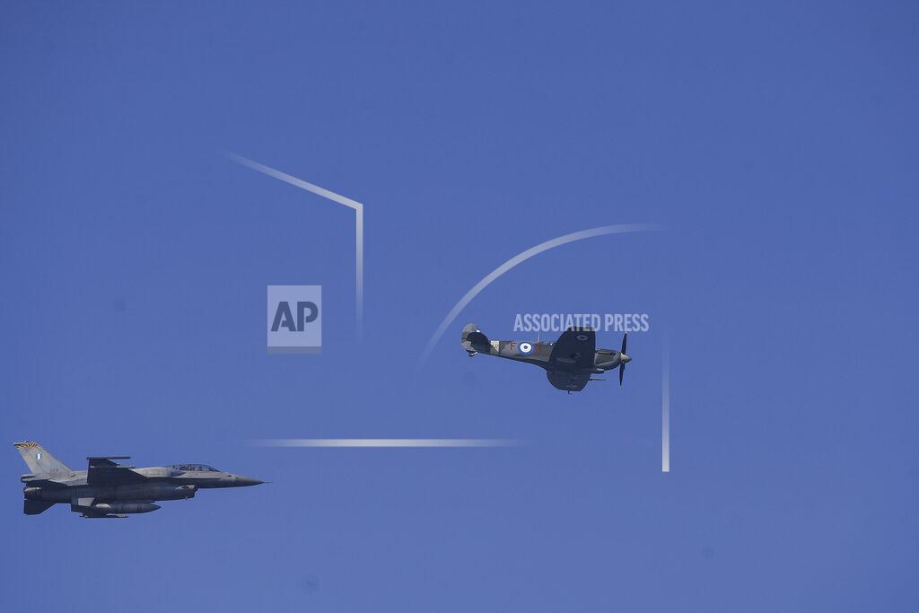 Giannis Papanikos A Hellenic Air Force F-16, left, takes part at the annual military parade next to a historic Spitfire a plane which took part in the WWII ,at the northern port city of Thessaloniki, Greece, on Thursday, Oct. 28, 2021 .The parade is held to celebrate Greece's refusal to align itself with a belligerent fascist Italy in 1940 and instead fight a much stronger opponent, a decision which dragged it into World War II and eventually led to a brutal occupation by Nazi Germany. (AP Photo/Giannis Papanikos)