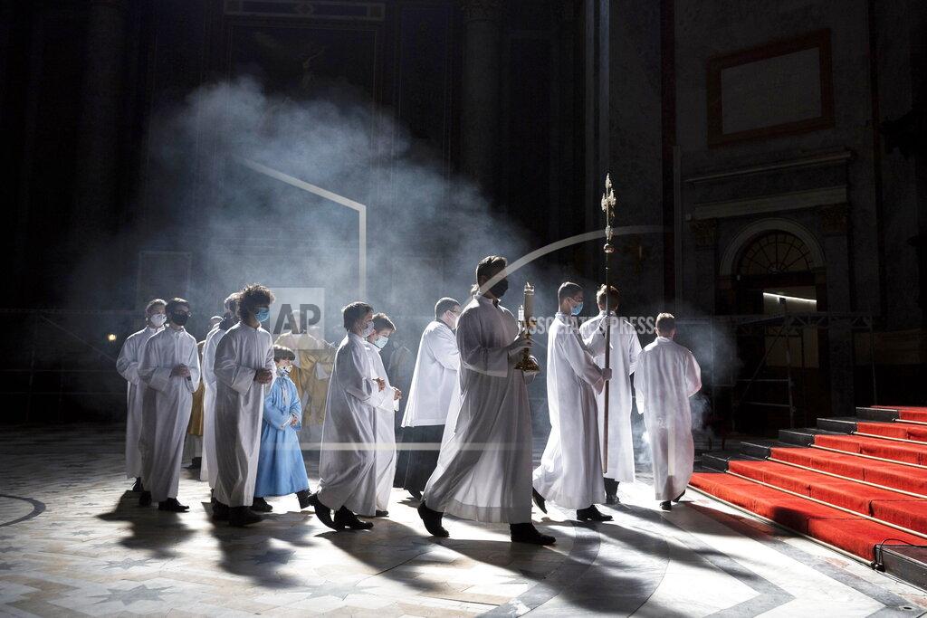 Marton Monus Clergyman and servers arrive for the Easter Sunday Mass celebrated by Primate of the Hungarian Catholic Church, Archbishop of Esztergom-Budapest, Cardinal Peter Erdo in the Esztergom Basilica in the City of Esztergom, Hungary, Sunday, April 4, 2021, during the pandemic coronavirus. The mass was broadcast on the Facebook account of the Archdiocese of Esztergom-Budapest and by a television channel as due to the pandemic of the novel coronavirus COVID-19 church services are not allowed to be attended by the public in Hungary. (Marton Monus/MTI via AP)