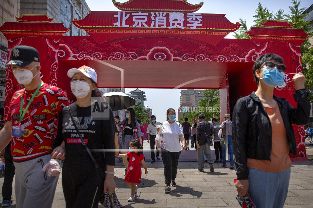 Mark Schiefelbein People wearing face masks to protect against the new coronavirus walk at a government event aiming to stimulate consumer demand and consumption in Beijing, Saturday, June 6, 2020. China's capital is lowering its emergency response level to the second-lowest starting Saturday for the coronavirus pandemic. That will lift most restrictions on people traveling to Beijing from Wuhan and surrounding Hubei province, where the virus first appeared late last year. (AP Photo/Mark Schiefelbein)