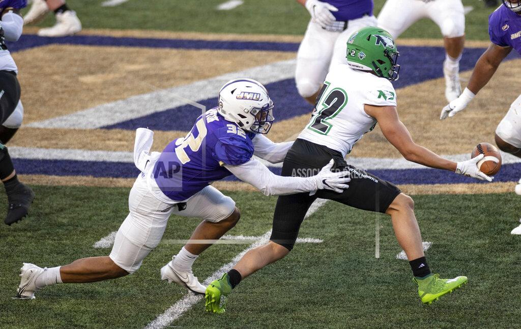 Daniel Lin North Dakota wide receiver Marcus Preston (12) flips the ball back to a teammate as he gets wrapped up by James Madison safety Mj Hampton (32) during the first half of a quarterfinal game in the NCAA FCS football playoffs in Harrisonburg, Va., Sunday, May 2, 2021. (Daniel Lin/Daily News-Record via AP)
