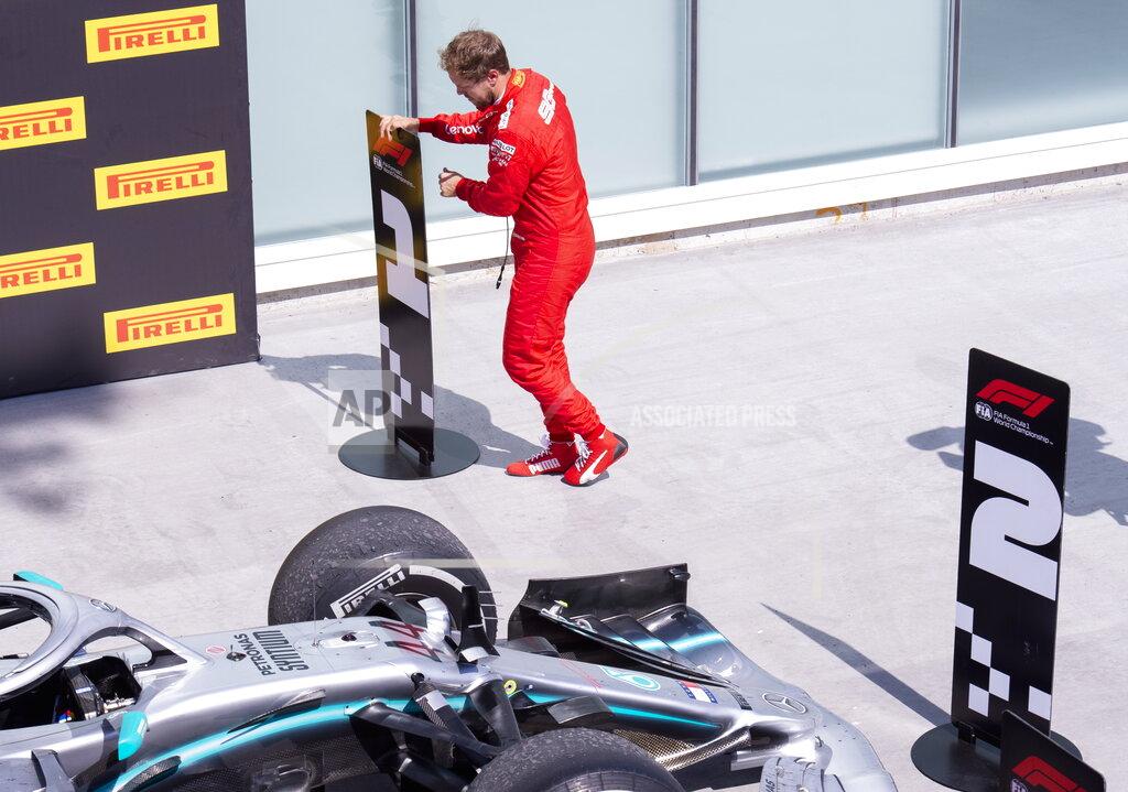 Paul Chiasson Ferrari driver Sebastian Vettel, of Germany, switches the standing markers to place Mercedes driver Lewis Hamilton, of Britain, second and himself first at the Formula One Canadian Grand Prix auto race in Montreal, Sunday, June 9, 2019. (Paul Chiasson/The Canadian Press via AP)