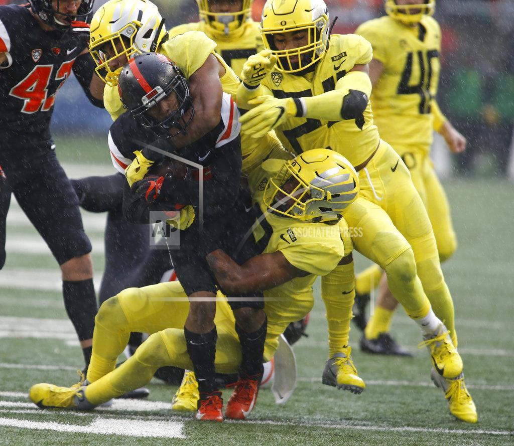 Timothy J. Gonzalez Oregon State kick returner Champ Flemings, center, get swarmed by Oregon defenders during the second half of an NCAA college football game in Corvallis, Ore., Friday, Nov. 23, 2018. Oregon won 55-15. (AP Photo/Timothy J. Gonzalez)