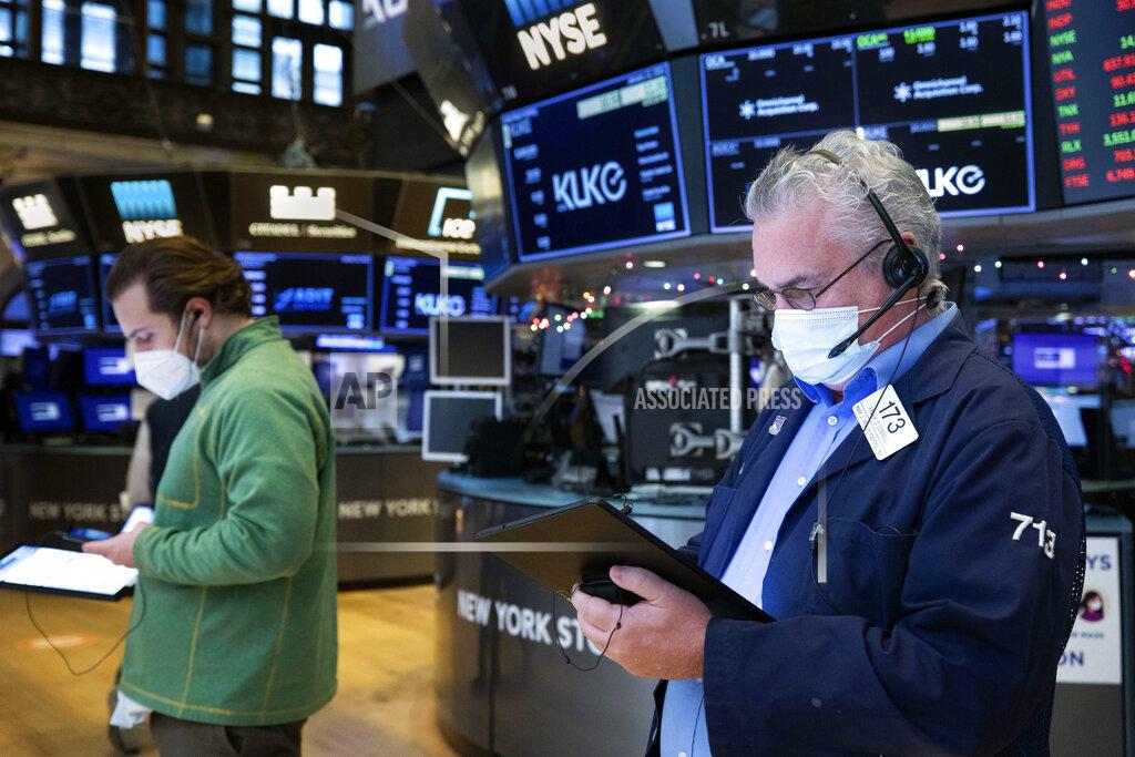 Colin Ziemer In this photo provided by the New York Stock Exchange, Frank O.Connell, right works with a feel trader on the floor, Tuesday, Jan. 12, 2021. U.S. stocks are drifting near their record heights Tuesday, while Treasury yields keep marching higher amid expectations that the economy will pull out of its slump after a powerful recovery sweeps the globe later this year. (Colin Ziemer/New York Stock Exchange via AP)