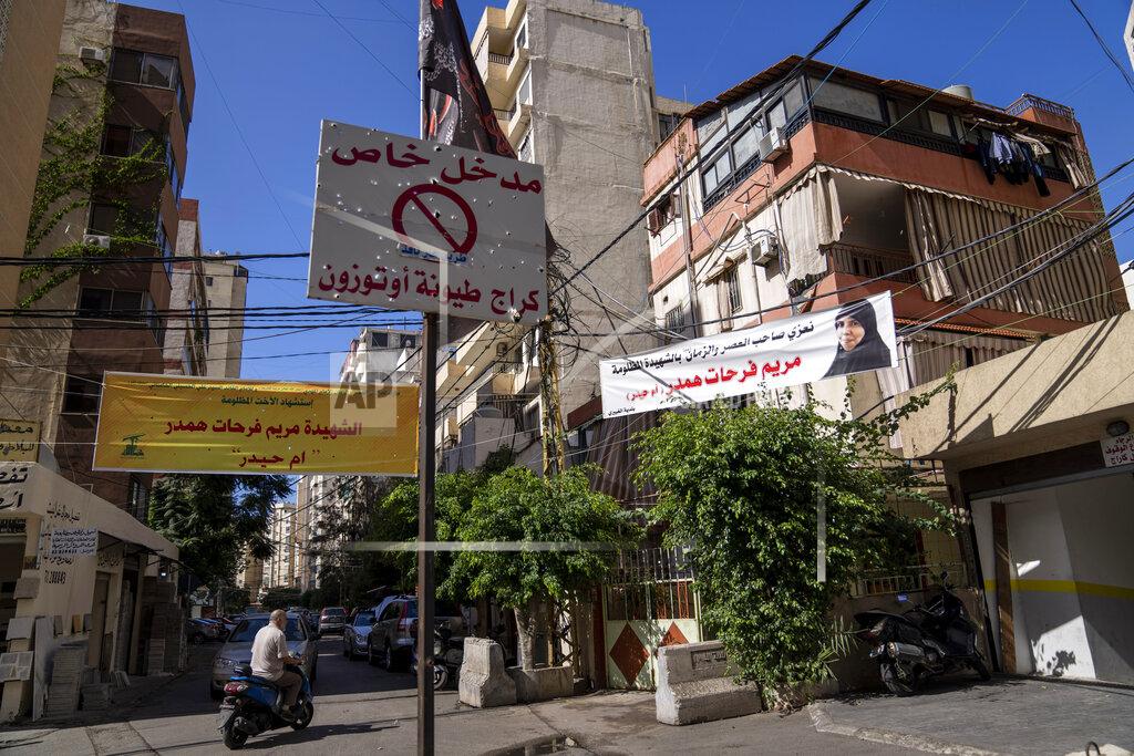 Hassan Ammar Condolences banners hang next to the house of Mariam Farhat Hamdar, who was killed during the deadly clashes that erupted last Thursday along a former 1975-90 civil war front-line between Muslim Shiite and Christian areas, in the Chiyah neighborhood of Beirut, Lebanon, Tuesday, Oct. 19, 2021. Arabic on the banner reads: "Condolences to the Lord of the Age (the Last of the 12th Shiite Imams) for the martyred unjustly Mariam Farhat Hamdar (or Um Haidar)". (AP Photo/Hassan Ammar)