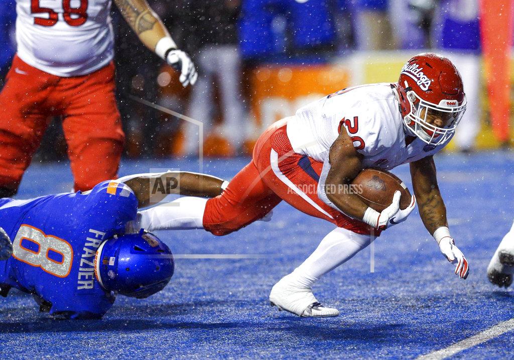 Steve Conner Fresno State running back Ronnie Rivers (20) stretches for additional yards as Boise State Jabril Frazier (8) grabs his leg during the first half of an NCAA college football game for the Mountain West championship, Saturday, Dec. 1, 2018, in Boise, Idaho. (AP Photo/Steve Conner)