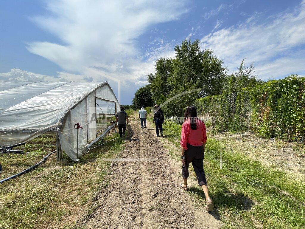 Susan Montoya Bryan This Aug. 31, 2021 photo shows U.S. Rep. Teresa Leger Fernández taking a tour of Santa Cruz Farm and Greenhouses in Espanola, New Mexico. The farm relies on a traditional irrigation system known as an acequia to water crops of corn, chile and blackberries. (AP Photo/Susan Montoya Bryan)