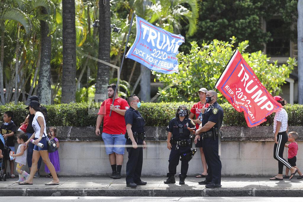 Marco Garcia Police speak to a group of Trump supporters who were campaigning near a polling station on Election Day, Tuesday, Nov. 3, 2020, in Honolulu. (AP Photo/Marco Garcia)