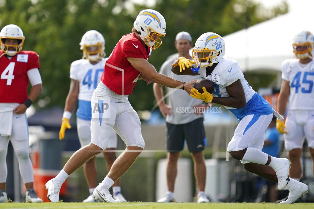 Ashley Landis Los Angeles Chargers quarterback Justin Herbert (10) and running back Isaiah Spiller (28) participate in drills at the NFL football team's practice facility in Costa Mesa, Calif. Monday, Aug. 1, 2022. (AP Photo/Ashley Landis)