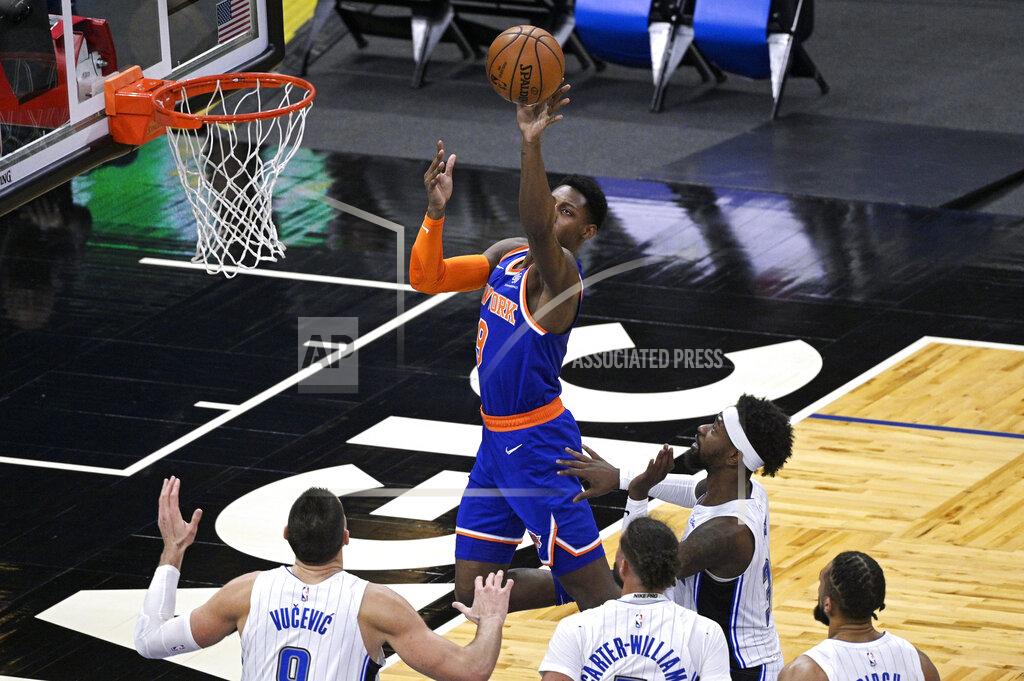 Phelan M. Ebenhack New York Knicks guard RJ Barrett (9) shoots in front of Orlando Magic center Nikola Vucevic (9), guard Michael Carter-Williams, guard Terrence Ross and center Khem Birch, right, during the second half of an NBA basketball game Wednesday, Feb. 17, 2021, in Orlando, Fla. (AP Photo/Phelan M. Ebenhack)