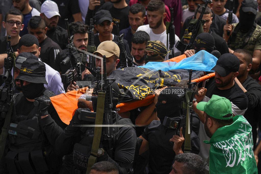 Majdi Mohammed Palestinian mourners, some armed, carry the body of Amjad al-Fayyed, 17, during his funeral in the West Bank refugee camp of Jenin, Saturday, May 21, 2022. Israeli troops shot and killed al-Fayyed as fighting erupted when soldiers entered a volatile town in the occupied West Bank early Saturday, the Palestinian health ministry and local media said. (AP Photo/Majdi Mohammed)