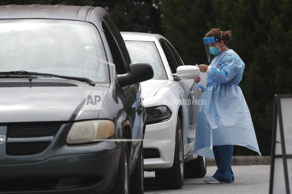 Gerry Broome FILE - In this July 9, 2020, file photo cars line up at a community coronavirus testing site operated by Cone Health and the county Health Department in Burlington, N.C. President Donald Trump’s push to inject new dynamics into the final weeks of the 2020 election is being overshadowed by the frightening realities of everyday life in the pandemic. Trump and his allies continue to downplay the health threat, but for swing voters on the ground in North Carolina, the coronavirus and the related economic challenges are a much more pressing concern than a Trump's push to fill a Supreme Court vacancy, his wild threats of voter fraud or angry civil rights protesters. (AP Photo/Gerry Broome, File)