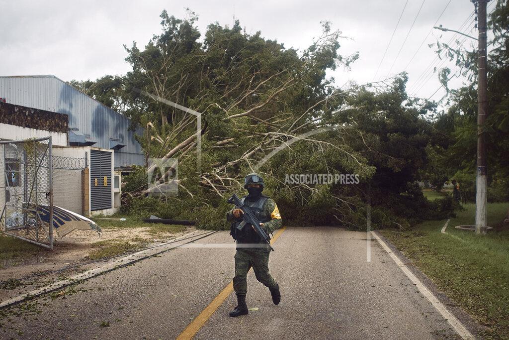 Andres Kudacki A soldier walks in front of a toppled tree after the passing of Hurricane Delta in Tizimin, Mexico, Wednesday, Oct. 7, 2020. Hurricane Delta made landfall Wednesday just south of the Mexican resort of Cancun as a Category 2 storm, downing trees and knocking out power to some resorts along the northeastern coast of the Yucatan Peninsula. (AP Photo/Andres Kudacki)