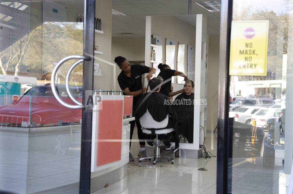 Denis Farrell A hairdressing salon operates on self-generated power during a power outage in a Johannesburg shopping centre, Thursday, June 30, 2022. South Africans are struggling in the dark to cope with increased power cuts that have hit households and businesses across the country. The rolling power cuts have been experienced for years but this week the country’s state-owned power utility Eskom extended them so that some residents and businesses have gone without power for more than 9 hours a day. (AP Photo/Denis Farrell)