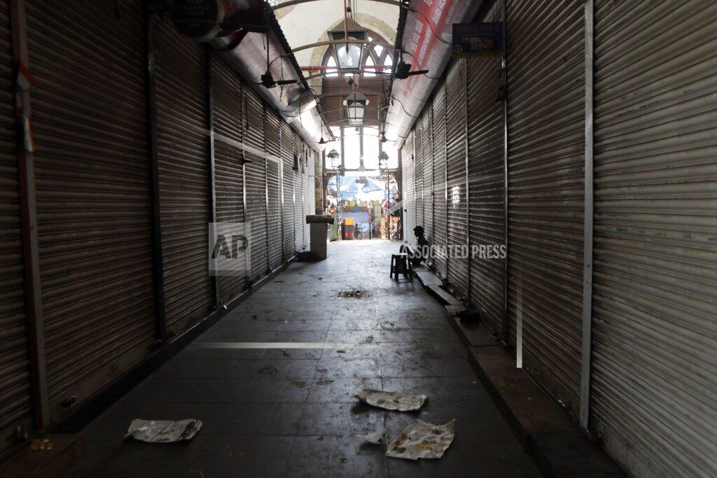 Rajanish Kakade FILE - In this March 24, 2020, file photo, a man sits outside a closed wholesale market in Mumbai, India. The International Monetary Fund has sharply lowered its forecast for global growth this year because it envisions far more severe economic damage from the coronavirus than it did just two months ago. (AP Photo/Rajanish Kakade, File)