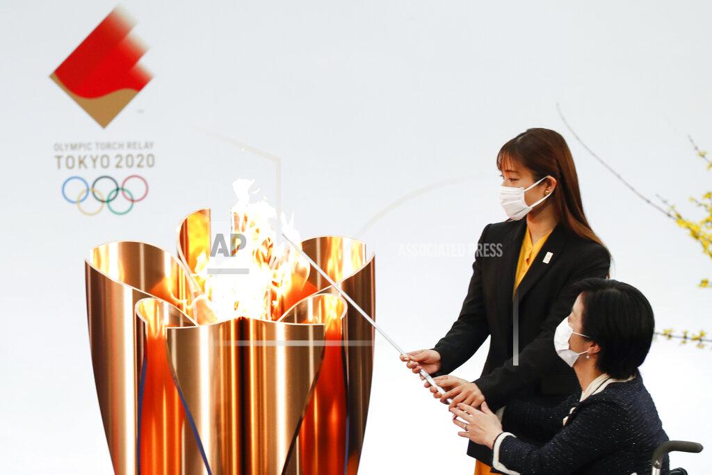 Kim Kyung-Hoon Japanese actress Satomi Ishihara, second from right, and Paralympian Aki Taguchi light the celebration cauldron on the first day of the Tokyo 2020 Olympic torch relay in Naraha, Fukushima prefecture, northeastern Japan, Thursday, March 25, 2021. The torch relay for the postponed Tokyo Olympics began its 121-day journey across Japan on Thursday and is headed toward the opening ceremony in Tokyo on July 23. (Kim Kyung-Hoon/Pool Photo via AP)