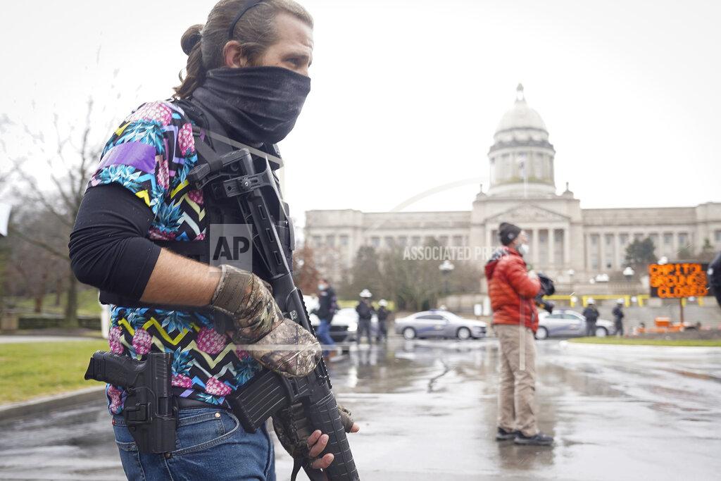 Bryan Woolston A Black Lives Matter activist carrying a semi-automatic rifle walks outside at the Capitol building in Frankfort, Ky., Wednesday, Jan 17, 2021. The Capitol, the Capitol complex, and surrounding grounds have been closed. (AP Photo/Bryan Woolston)