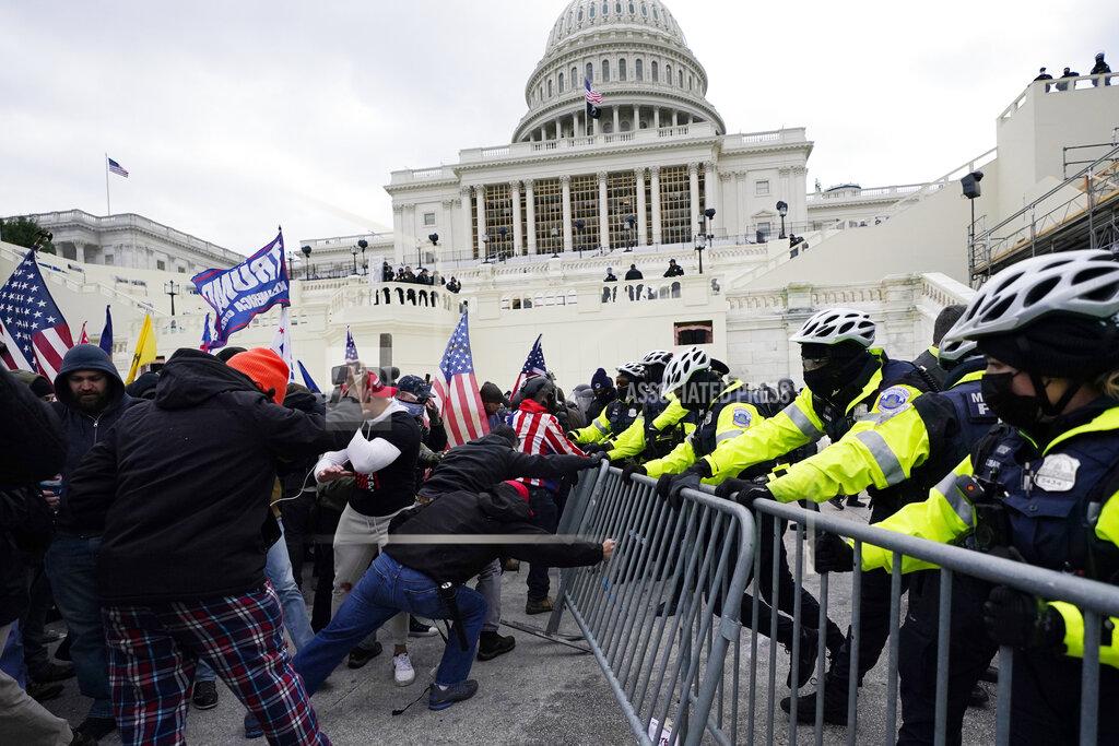 FILE - In this Wednesday, Jan. 6, 2021 file photo, Trump supporters try to break through a police barrier at the Capitol in Washington. Right-wing extremism has previously mostly played out in isolated pockets of America or in smaller cities. In contrast, the deadly attack by rioters on the U.S. Capitol targeted the very heart of government. It brought together members of disparate groups, creating the opportunity for extremists to establish links with each other. (AP Photo/Julio Cortez, File)