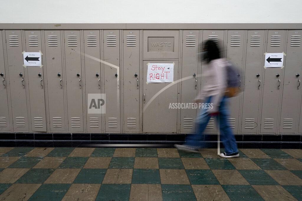 Charlie Riedel A student walks between classes at Wyandotte High School in Kansas City, Kan., on the first day of in-person learning Wednesday, March 30, 2021. The school, like other schools nationwide, has made extra efforts to keep kids at risk of dropping out engaged as classes went virtual due to the pandemic. (AP Photo/Charlie Riedel)