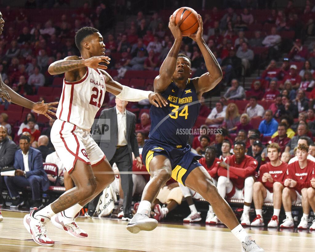 Kyle Phillips West Virginia guard Oscar Tshiebwe (34) goes up for a shot ahead of Oklahoma forward Kristian Doolittle (21) during the first half of an NCAA college basketball game in Norman, Okla., Saturday, Feb. 8, 2020. (AP Photo/Kyle Phillips)