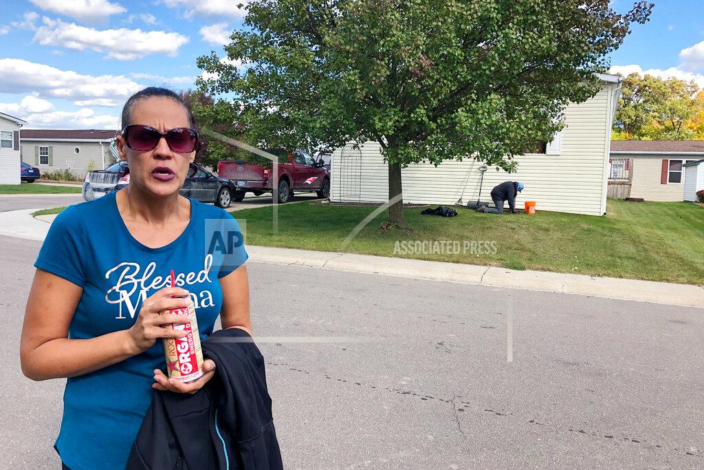 Tammy Webber Melissa Merola stands outside the home where Ty Garbin was arrested, in Hartland Township, Mich., Thursday, Oct. 8, 2020. Merola said she watched as police, the FBI and what she described as "the military" converged on a mobile home Wednesday, and eventually took two men out in handcuffs. Garbin is one of multiple people who have been charged in federal court with plotting to kidnap Michigan Democratic Gov. Gretchen Whitmer at her vacation home. (AP Photo/Tammy Webber)