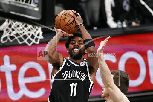 FILE - Brooklyn Nets guard Kyrie Irving (11) shoots against the Milwaukee Bucks during the second half of Game 1 of an NBA basketball second-round playoff series in New York, in this Saturday, June 5, 2021, file photo. Players like Kyrie Irving, who has refused to say if he will be vaccinated against COVID-19, will be subject to testing on all NBA practice, travel and game days this season. Fully vaccinated players will not. (AP Photo/Adam Hunger, File)