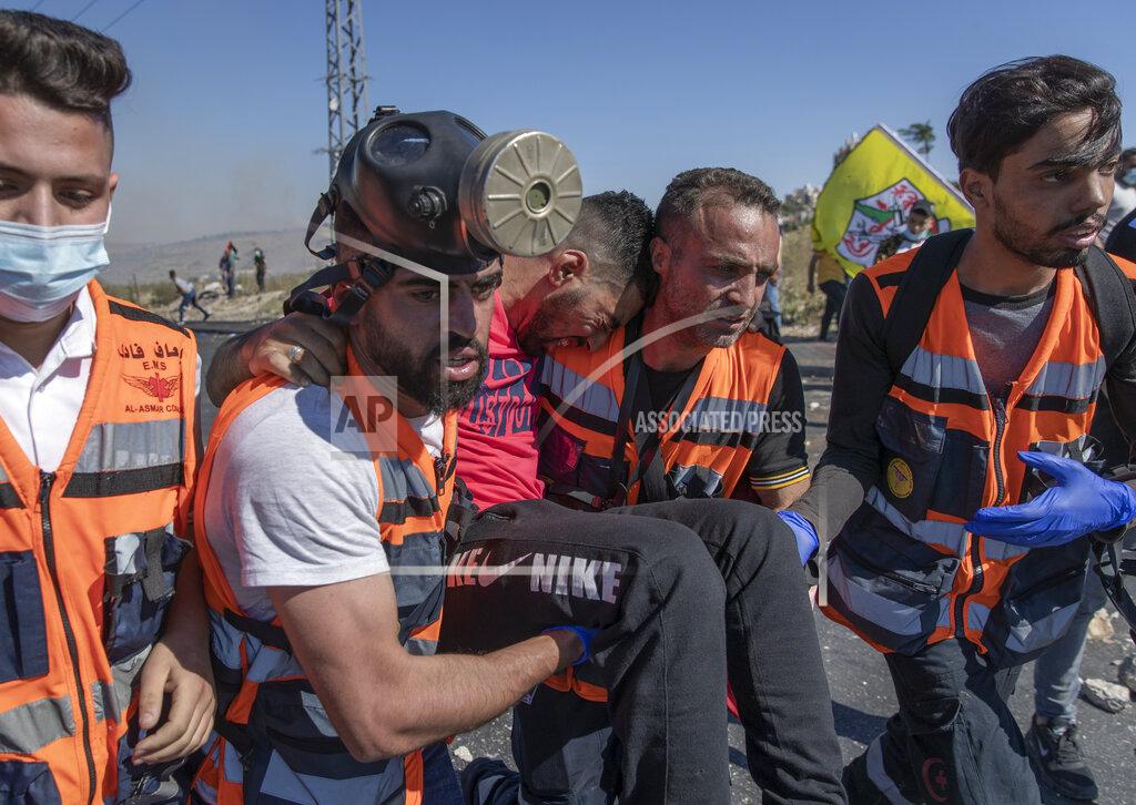 Nasser Nasser Palestinian paramedics evacuate an injured protester during clashes with Israeli army soldiers at the northern entrance of the West Bank city of Ramallah, Friday, May 14, 2021. Palestinian health officials said that several Palestinians were killed by Israeli army fire during protests that took place in several locations across the West Bank on Friday. (AP Photo/Nasser Nasser)