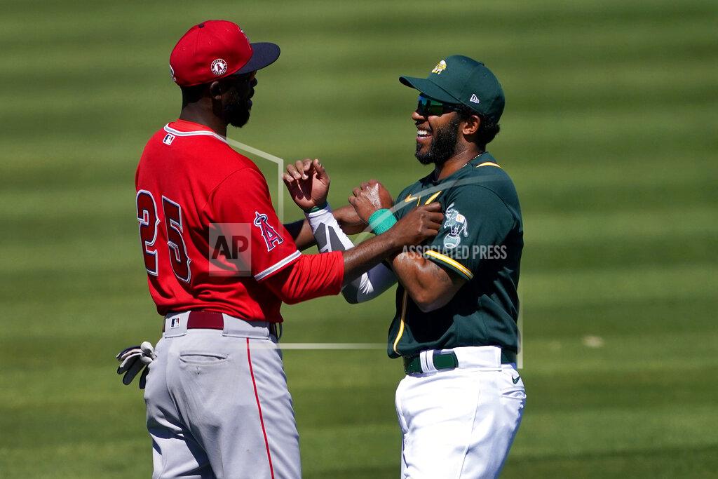 Matt York Los Angeles Angels' Dexter Fowler (25) greets Oakland Athletics' Elvis Andrus prior to a spring training baseball game, Friday, March 5, 2021, in Mesa, Ariz. (AP Photo/Matt York)