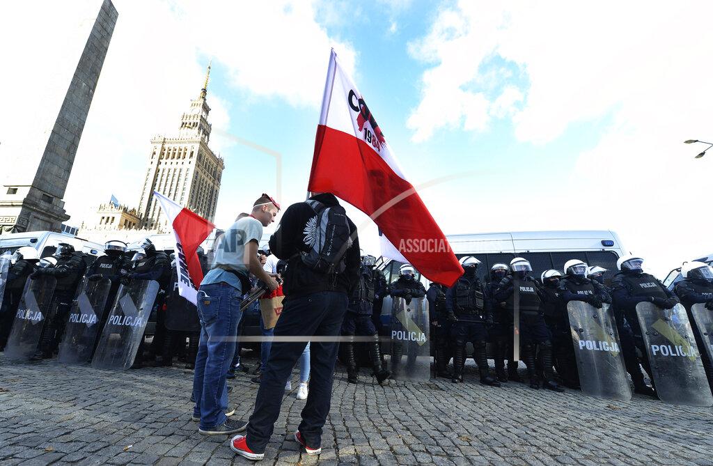 Czarek Sokolowski Polish police face protesters angry over new restrictions aimed at fighting the coronavirus pandemic, in Warsaw, Poland, Saturday, Oct. 24, 2020. The protesters included entrepreneurs, far-right politicians, football fans and vaccine opponents. The protesters, many wearing no protective masks, violated a new restriction on gatherings of more people. The clashes come amid rising social tensions and as new restrictions just short of a full lockdown took effect Saturday.(AP Photo/Czarek Sokolowski)