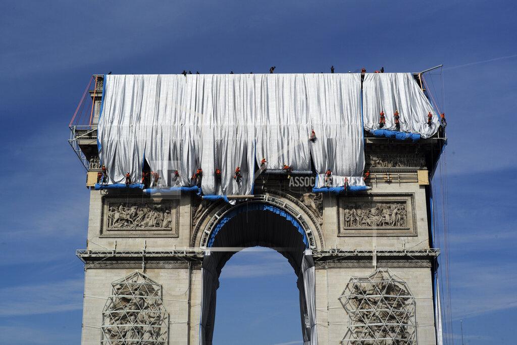 Rafael Yaghobzadeh Workers wrap the Arc de Triomphe monument, Sunday, Sept. 12, 2021 in Paris. The "L'Arc de Triomphe, Wrapped" project by late artist Christo and Jeanne-Claude will be on view from, Sept.18 to Oct. 3, 2021. The famed Paris monument will be wrapped in 25,000 square meters of fabric in silvery blue, and with 3,000 meters of red rope. (AP Photo/Rafal Yaghobzadeh)