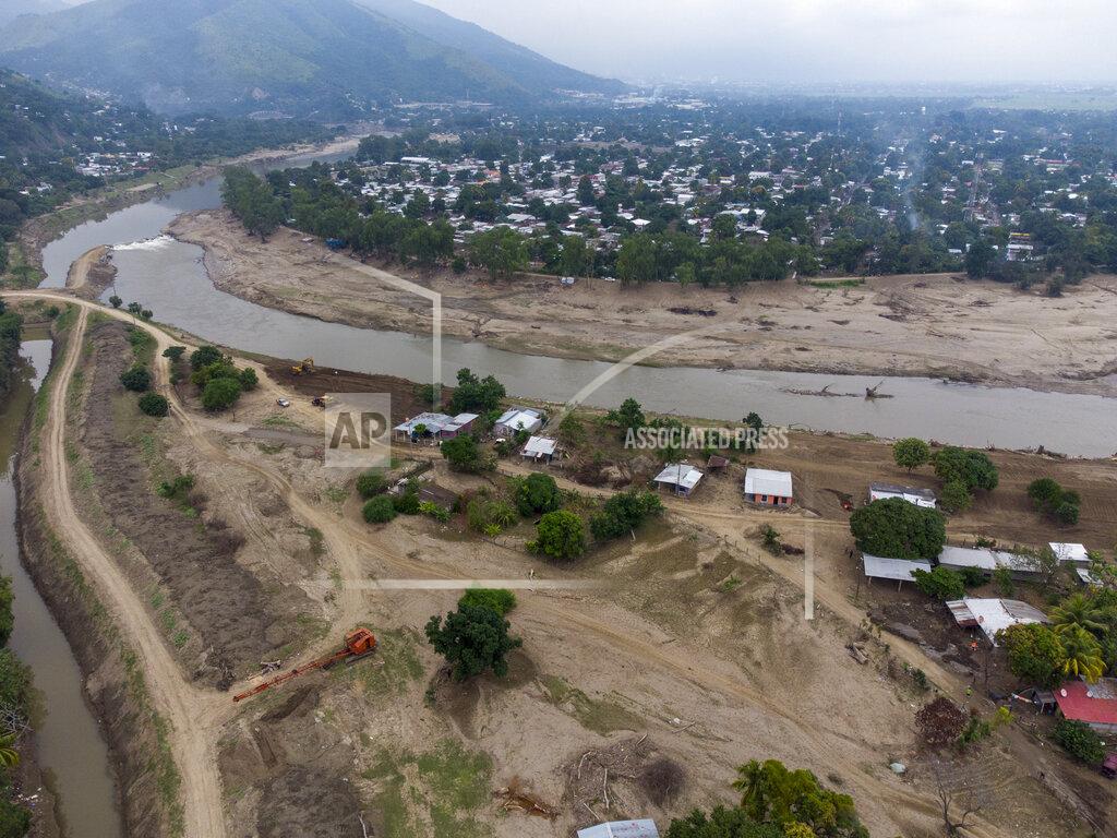 Moises Castillo The Chamelecon River flows by the Saviñon Cruz neighborhood which was completely submerged during last year's hurricanes Eta and Iota in San Pedro Sula, Honduras, Tuesday, Jan. 12, 2021. The dual hurricanes affected an estimated 4 million Honduras’ 10 million people, and the northern territory has also been Honduras' hardest hit by COVID-19 infections. (AP Photo/Moises Castillo)