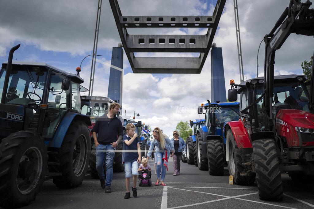 Peter Dejong Protesting farmers block a draw bridge at a lock in the Princess Margriet canal, preventing all ship traffic from passing in Gaarkeuken, northern Netherlands, Monday, July 4, 2022. Dutch farmers angry at government plans to slash emissions also used tractors and trucks Monday to blockade supermarket distribution centers, the latest actions in a summer of discontent in the country's lucrative agricultural sector. (AP Photo/Peter Dejong)