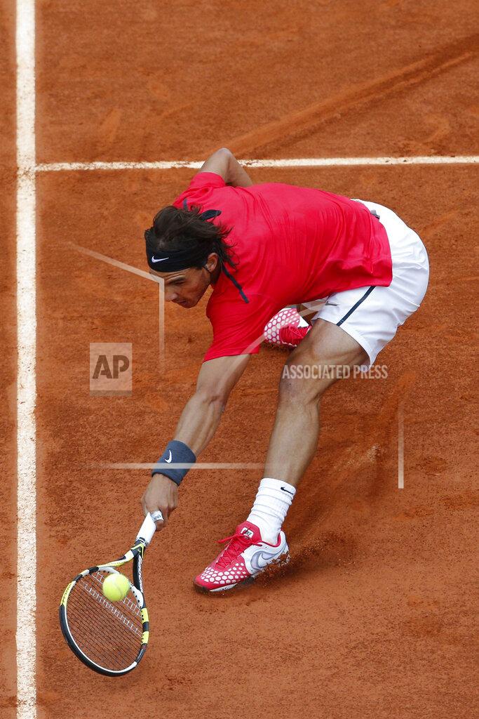 Christophe Ena FILE- In this Sunday June 10, 2012, image, Rafael Nadal of Spain slides to the net to return in the mens final match against Novak Djokovic of Serbia at the French Open tennis tournament in Roland Garros stadium in Paris. Sliding is one of the keys to success at the French Open, with the start of the French Open postponed until September because of the coronavirus, the ability to glide along the ground to reach shots that others can't, is one of the skills that makes Rafael Nadal so successful on clay courts. (AP Photo/Christophe Ena, File)