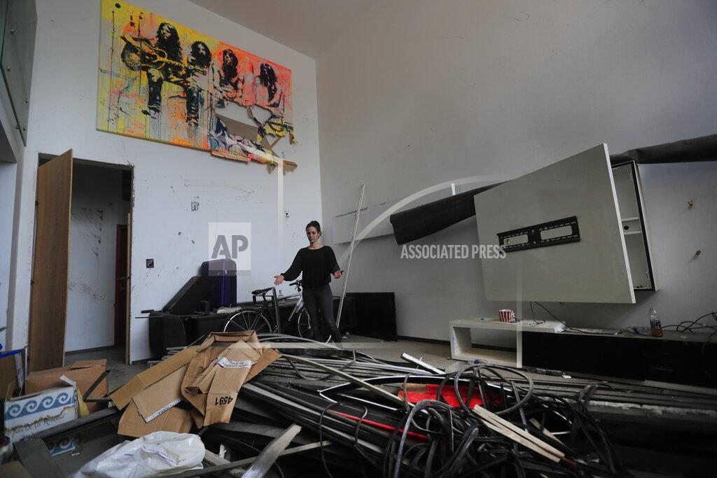 Hussein Malla Joana Dagher, 33, who lost her memory for two full months from the trauma she suffered in the massive August explosion at the Beirut port, including a cerebral contusion and brain lesions, shows her damaged apartment, in Beirut, Lebanon, Wednesday, Jan. 27, 2021. The mental health impact of the Beirut explosion that killed more than 200 and wounded more than 6,000 continues to lay its heavy weight on those who managed to survive the day. (AP Photo/Hussein Malla)