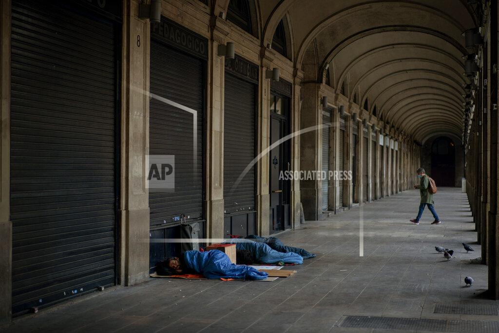 Emilio Morenatti Homeless people sleep on a square where restaurants are closed due to sharpest resurgences of the new coronavirus in Barcelona, Spain, Monday, Oct. 19, 2020. Several Spanish regions adopt new restrictions to deal with the health emergency. Spain is nearing one million infections since the onset of the pandemic, the most in Europe. (AP Photo/Emilio Morenatti)