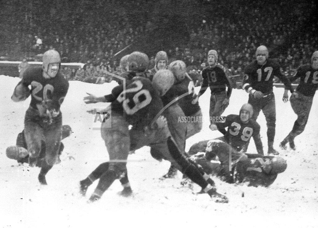 Uncredited FILE - In this Nov. 21, 1937, file photo, Washington Redskins' Cliff Battles, left, carries the ball against the Cleveland Rams in the third quarter of a football game at Cleveland Stadium. (AP Photo/Cleveland Plain Dealer)/The Plain Dealer via AP)