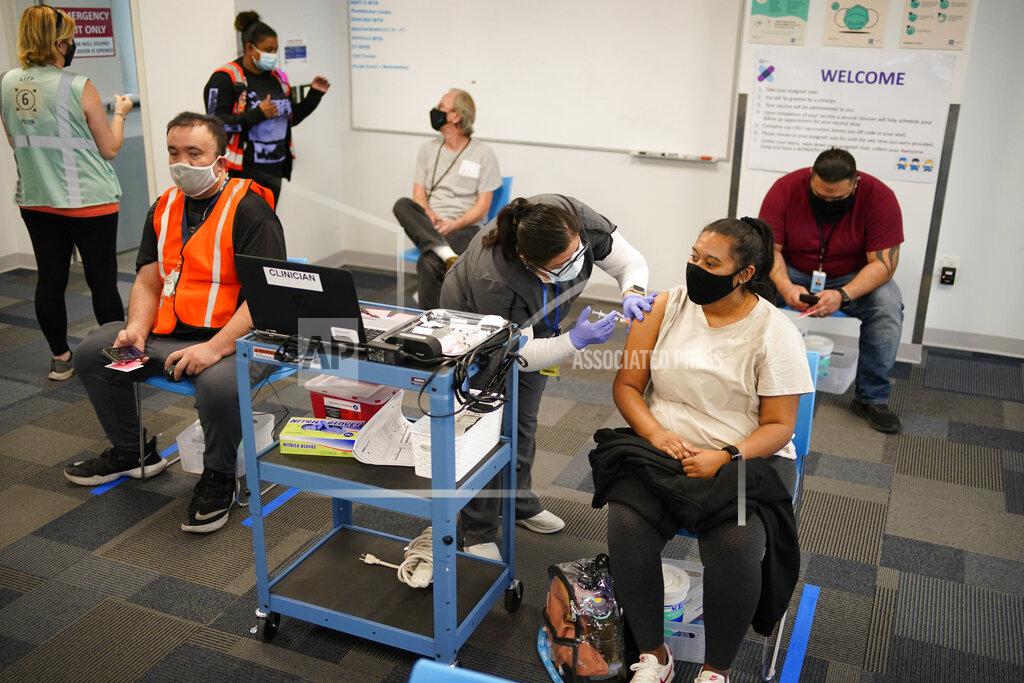 John Locher Registered nurse Rocio Ortiz administers a vaccine shot at a vaccination event for workers at an Amazon Fulfillment Center, Wednesday, March 31, 2021, in North Las Vegas, Nev. A growing number of companies and labor unions are directly securing coronavirus vaccines for their workers. Amazon and some other large companies have hosted on-site inoculations, while smaller operations have helped book appointments for their workers. (AP Photo/John Locher)