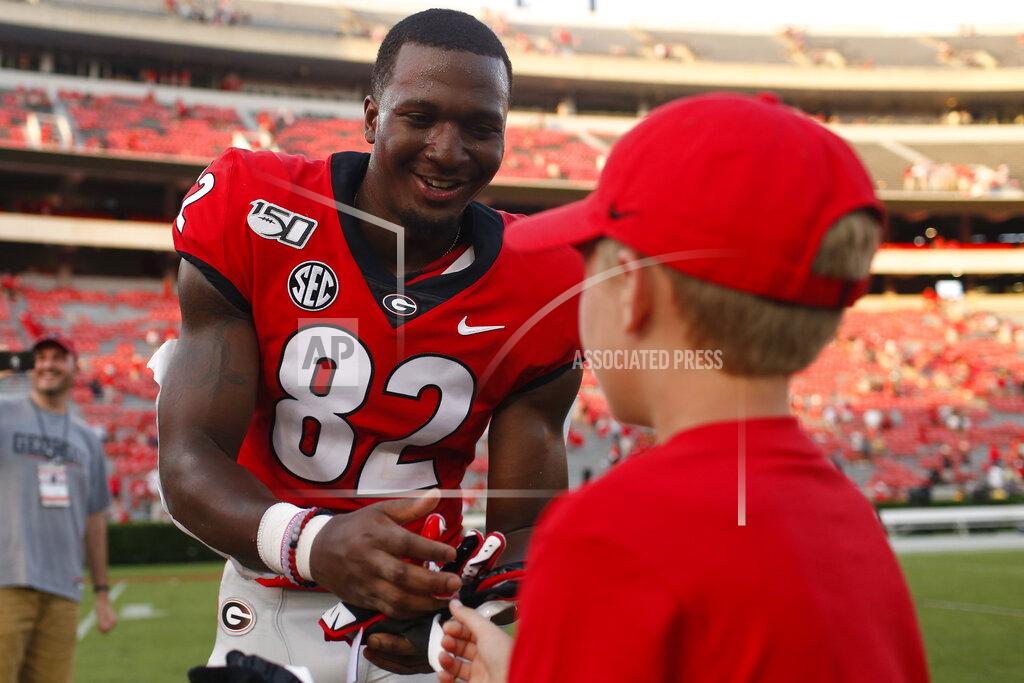 Joshua L. Jones Georgia tight end Kolby Wyatt (82) gives a youth his game gloves after an NCAA college football game against Murray State, Saturday, Sept. 7, 2019, in Athens, Ga. (Joshua L. Jones/Athens Banner-Herald via AP)