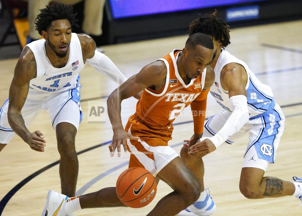 Kathy Kmonicek Texas guard Matt Coleman III (2) drives between North Carolina guards Leaky Black (1) and R.J. Davis (4) during the first half of an NCAA college basketball game for the championship of the Maui Invitational, Wednesday, Dec. 2, 2020, in Asheville, N.C. (AP Photo/Kathy Kmonicek)
