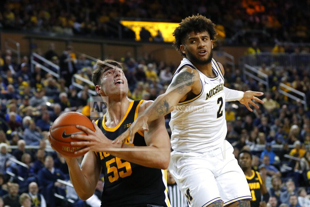 Paul Sancya Michigan forward Isaiah Livers (2) fouls Iowa center Luka Garza (55) in the second half of an NCAA college basketball game in Ann Arbor, Mich., Friday, Dec. 6, 2019. (AP Photo/Paul Sancya)