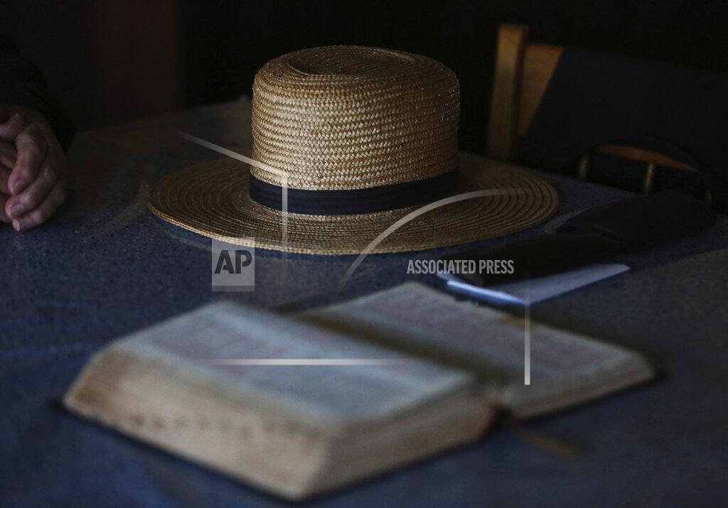 Jessie Wardarski In this Saturday, May 16, 2020, photo, Bishop Marvin's straw hat sits on his living room table next to his Bible in German as he prepares for the Sunday service in Ephrata, Pa. The Old Order Stauffer Church, which shuns most modern technology including the internet, telephones and cars, has been isolated in the Mennonite Valley without church service as it followed the state's COVID-19 stay-at-home order. Gov. Tom Wolf's order exempted religious activity, but strongly discouraged gatherings. (AP Photo/Jessie Wardarski)