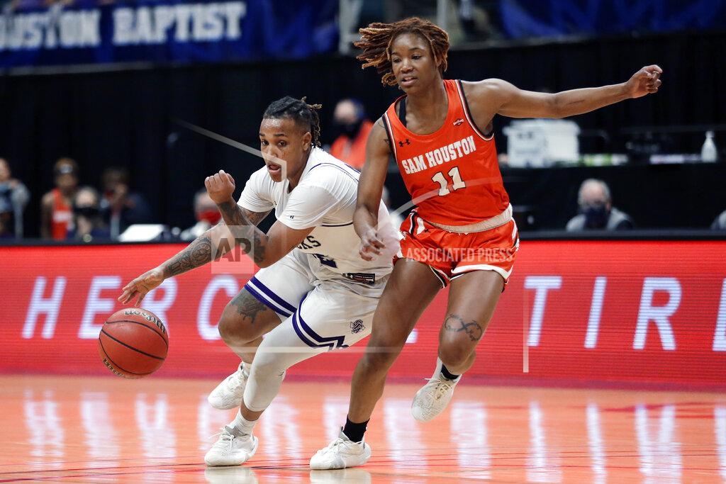 Michael Wyke Stephen F. Austin guard Zya Nugent (22) drives around Sam Houston State forward Courtney Cleveland (11) during the second half of an NCAA college basketball game for the Southland Conference women's tournament championship Sunday, March 14, 2021, in Katy, Texas. (AP Photo/Michael Wyke)
